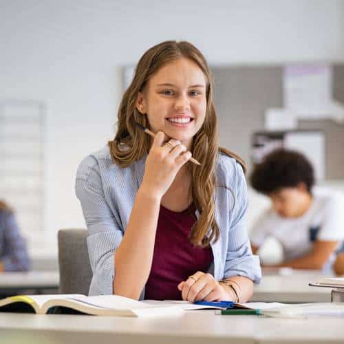 Smiling student studying in classroom setting.