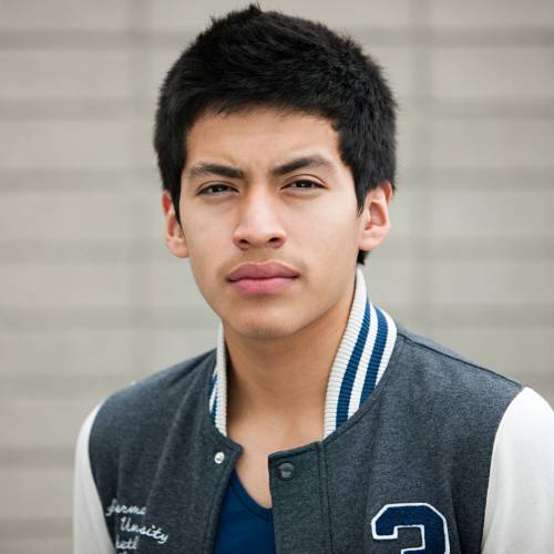 Young man in varsity jacket looking serious.