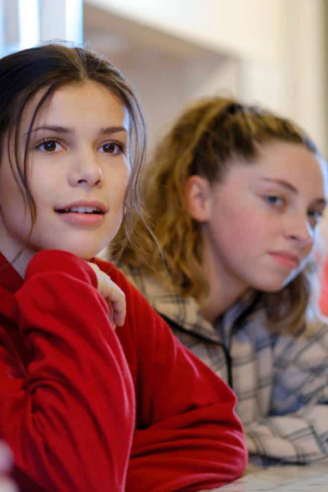 Two teens attentively looking onwards.